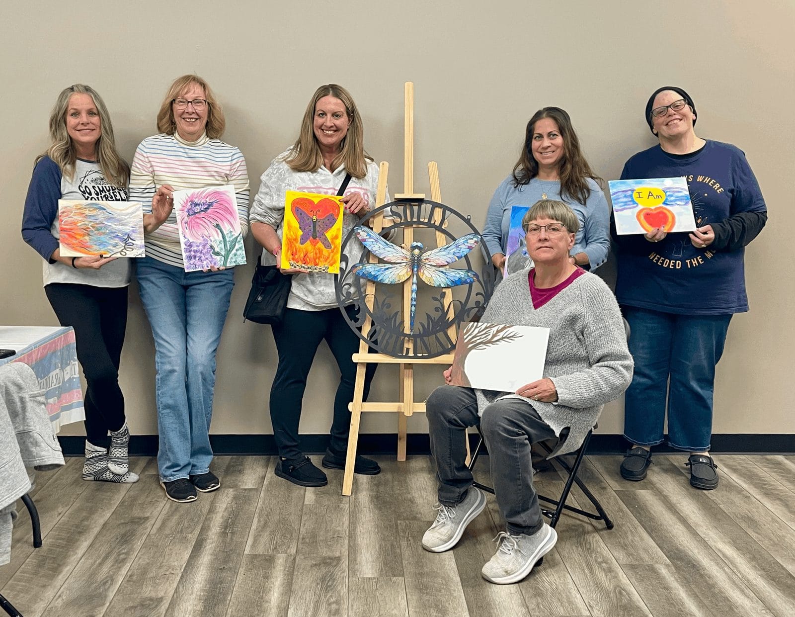 Workshop guests holding up their paintings