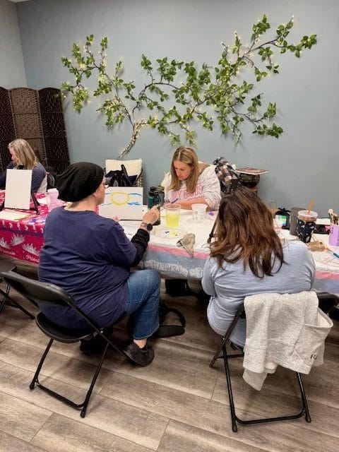 Workshop guests painting together around a table